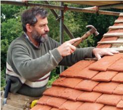 Buildings Manager John Hyde-Trutch constructing a traditional peg tile roof on Chiltern Open Air Museum's recently reconstructed wychert (white earth) cottage from Haddenham in Aylesbury