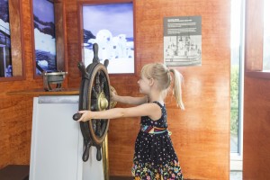 Taking the wheel of the St. Roch at Vancouver Maritime Museum's new St. Roch Wheelhouse Experience. (credit Flora Gordon, Vancouver Maritime Museum)