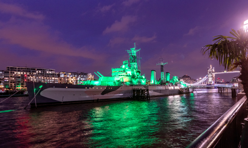 The HMS Belfast in London, lit up in green