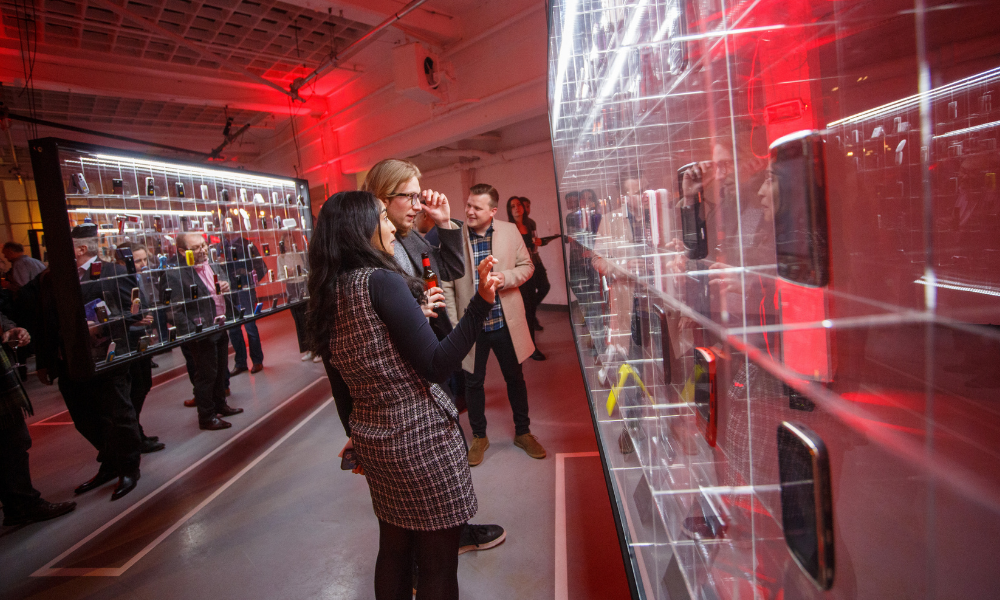 Visitors at the Mobile Phone Museum launch event look at a wall of exhibits