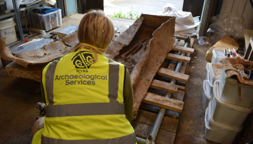 Excavating the Lead Coffin indoors (Leeds City Council)